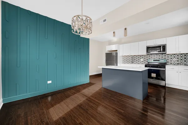 a kitchen with stainless steel appliances granite countertop a sink dishwasher a stove and a refrigerator with wooden floor