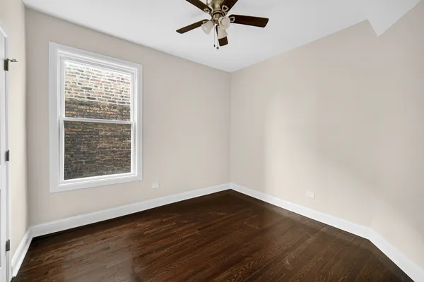 a view of a big room with wooden floor and windows