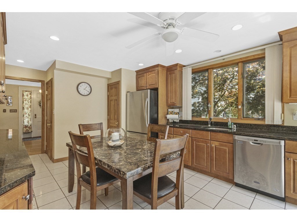 230 Clark Road Brookline, MA 02445 - Photo 6 of 27 a open kitchen with stainless steel appliances granite countertop a table chairs and a refrigerator