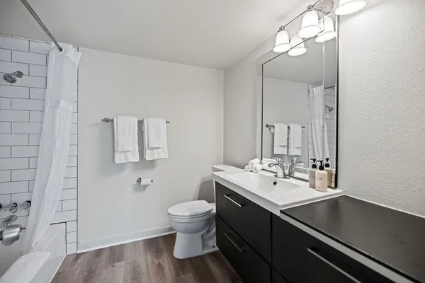 a bathroom with a sink a toilet and shower