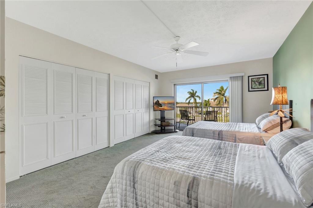 60 West Pelican Street, Unit 401 Naples, FL 34113 - Photo 20 of 31 a bed room with a bed and a chandelier