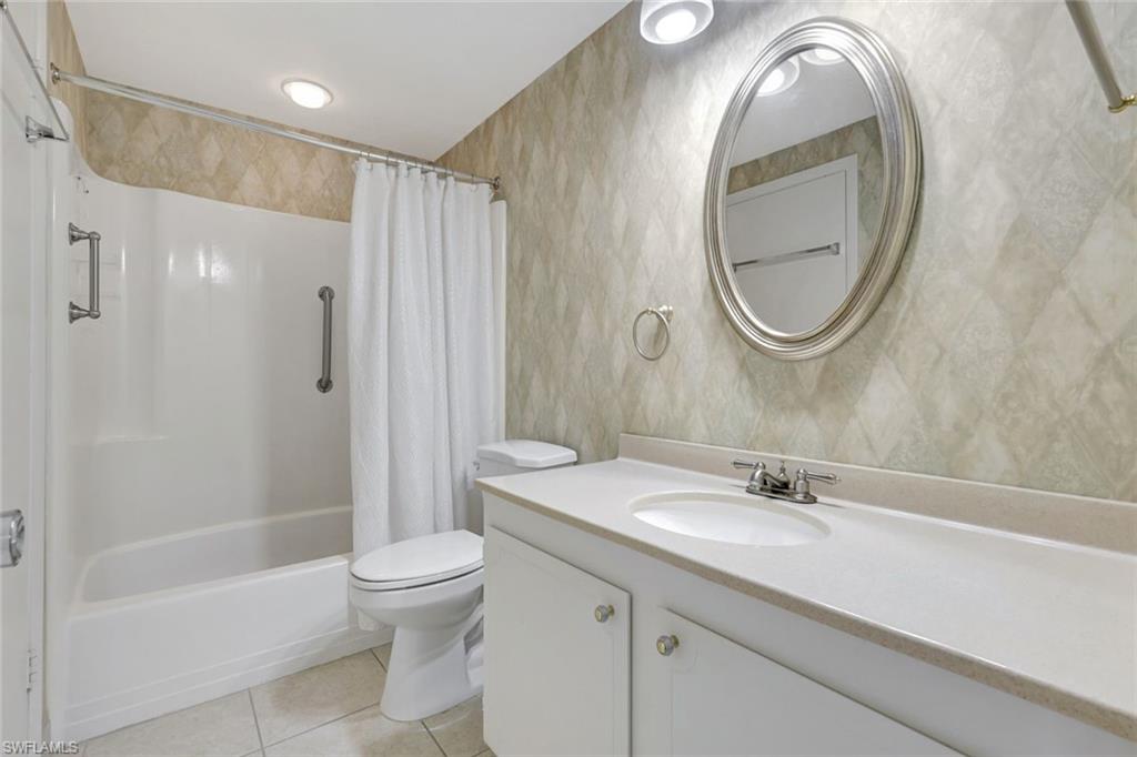 60 West Pelican Street, Unit 401 Naples, FL 34113 - Photo 23 of 31 a bathroom with a sink a toilet and a mirror
