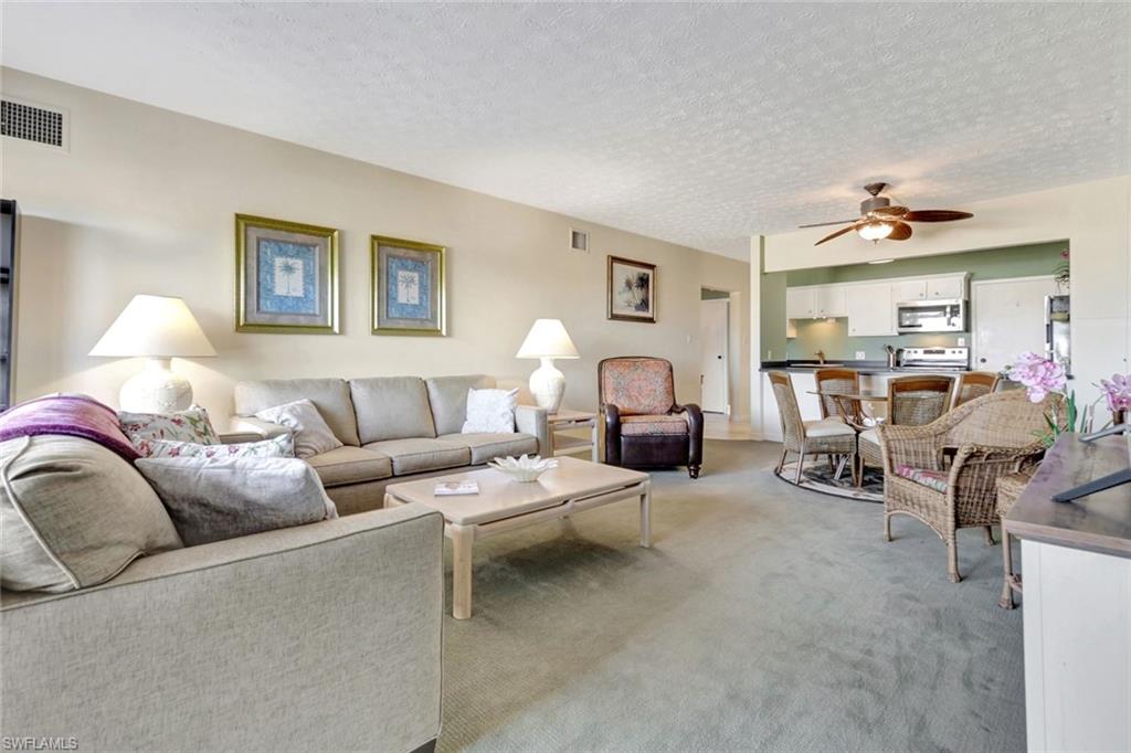 60 West Pelican Street, Unit 401 Naples, FL 34113 - Photo 7 of 31 a living room with furniture and a lamp