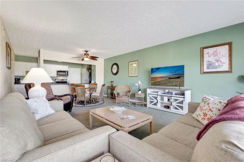 60 West Pelican Street, Unit 401 Naples, FL 34113 - Photo 8 of 31 a living room with furniture and a flat screen tv