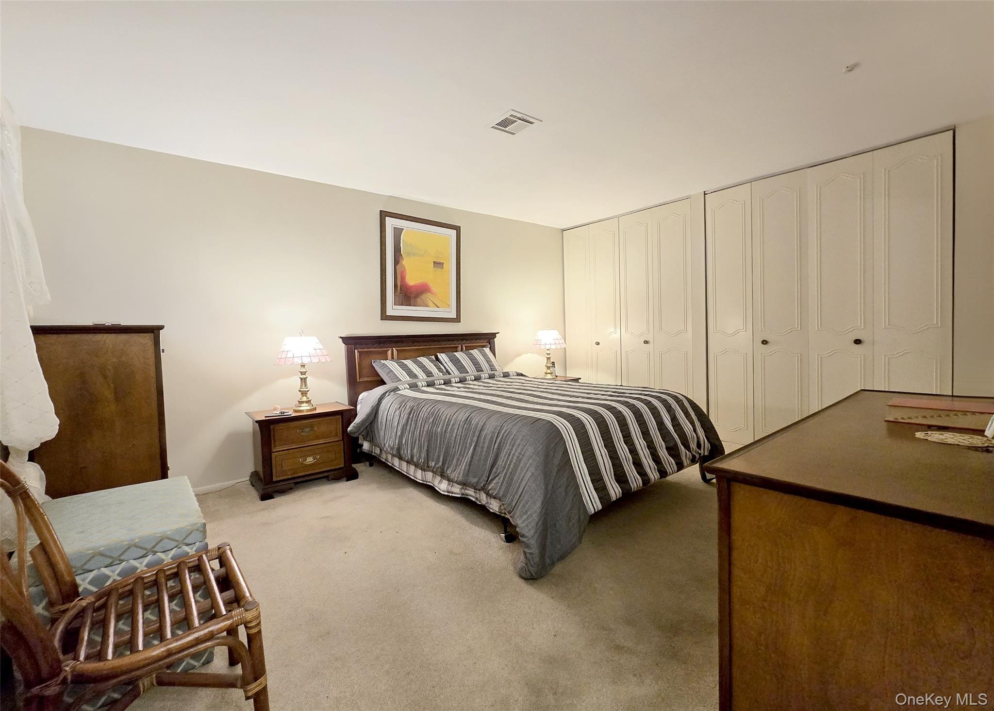 289 Cardiff Court, Unit B Ridge, NY 11961 - Photo 13 of 20 a bedroom with a bed and chair