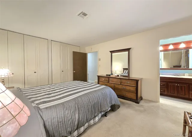 a bathroom with a granite countertop sink a toilet a shower and a mirror