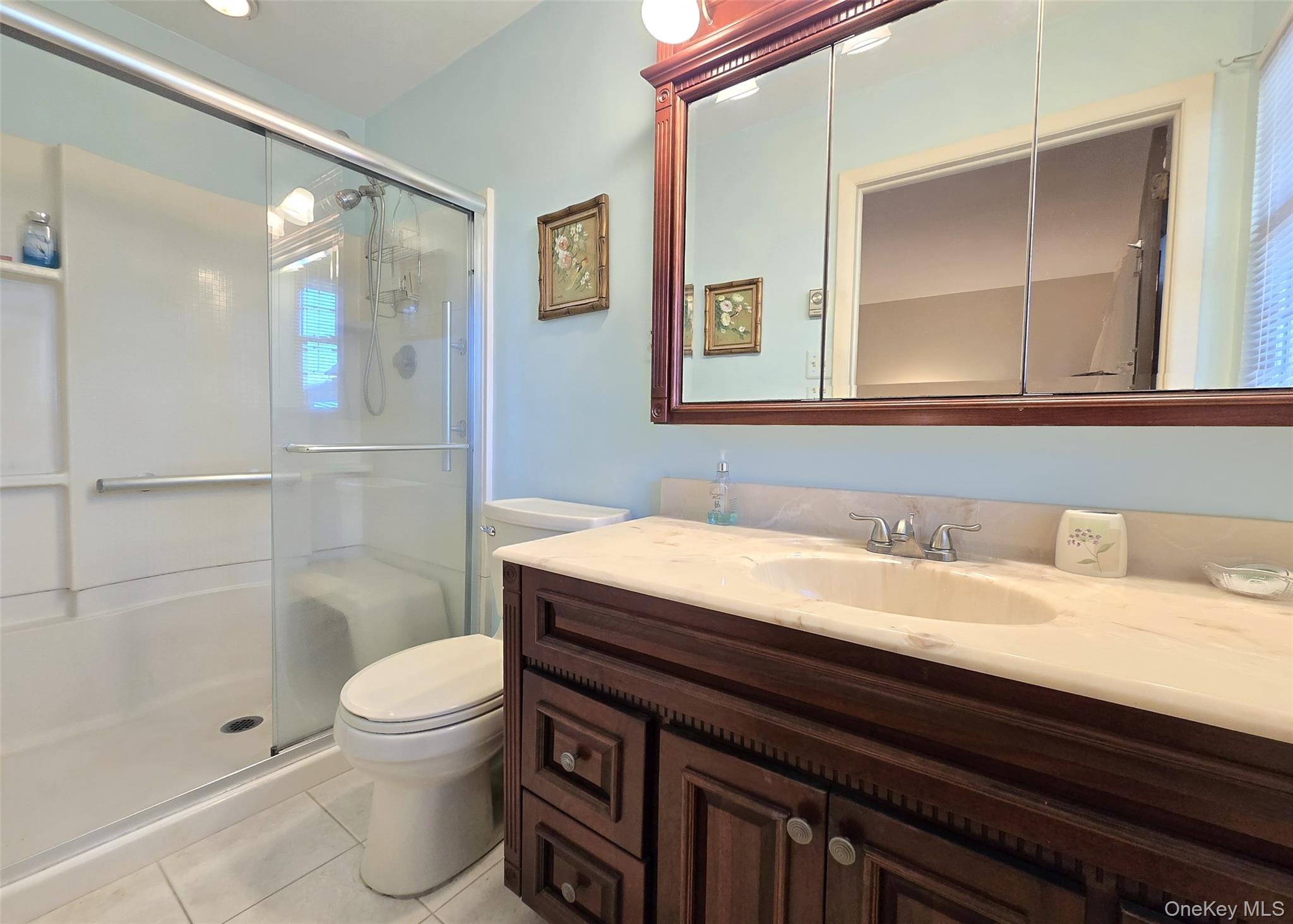 289 Cardiff Court, Unit B Ridge, NY 11961 - Photo 15 of 20 a bathroom with a granite countertop sink a toilet a shower and a mirror