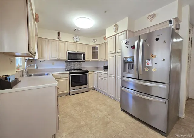 a kitchen with cabinets stainless steel appliances and sink