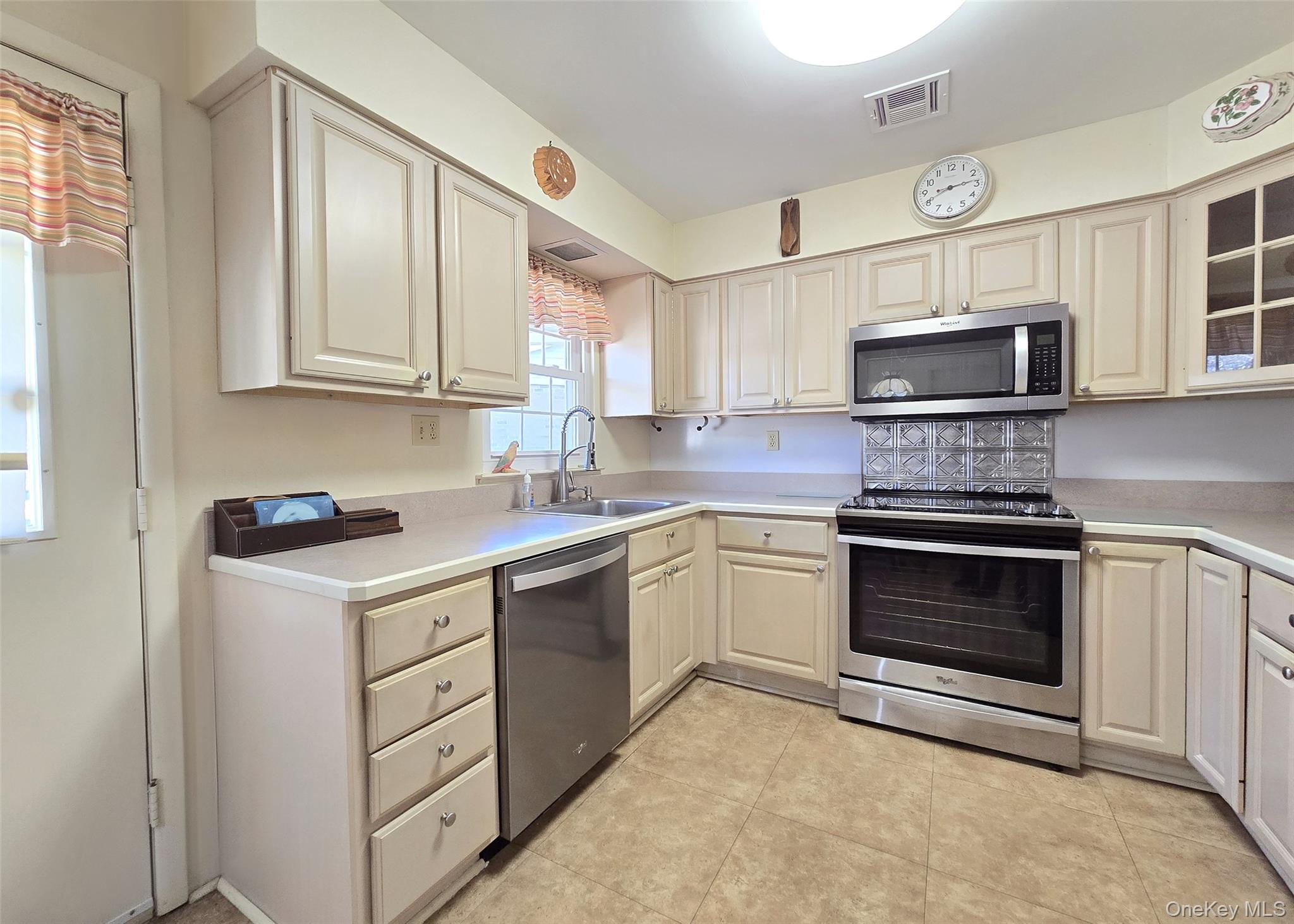 289 Cardiff Court, Unit B Ridge, NY 11961 - Photo 7 of 20 a kitchen with cabinets stainless steel appliances and sink