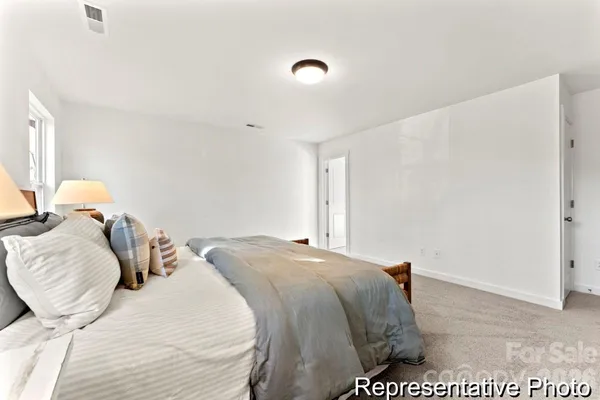 a bed sitting in a bedroom next to a window