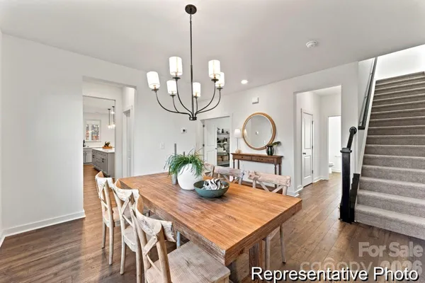 a view of a dining room with furniture a chandelier and wooden floor