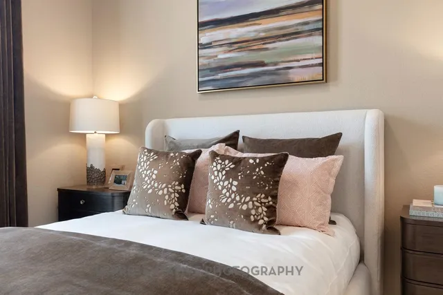 a large bed sitting in a bedroom next to a lamp