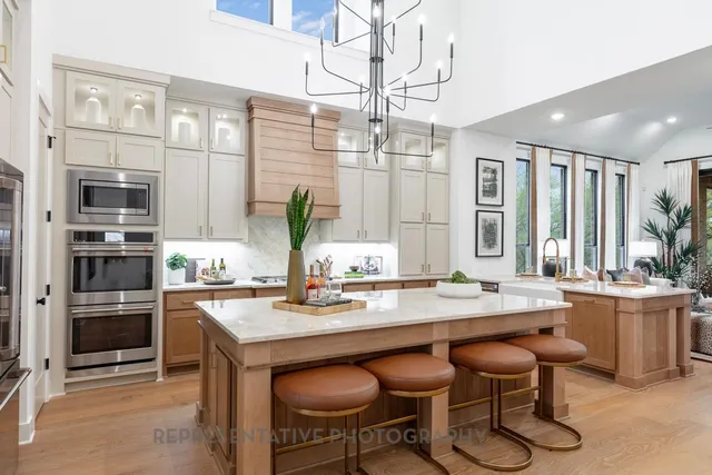 a kitchen with a stove a sink and chairs