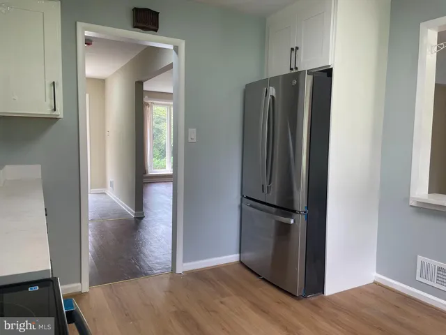 a view of kitchen with stainless steel appliances wooden floor and staircase
