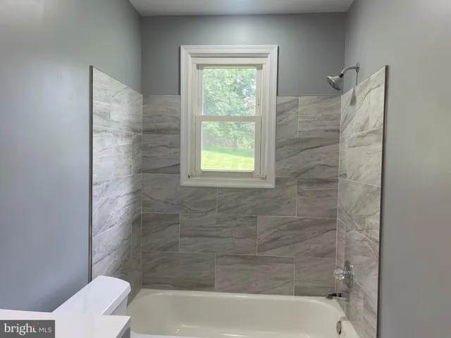 a bathroom with a window bathtub and toilet