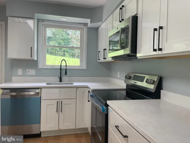 a kitchen with stainless steel appliances a stove a sink and a microwave