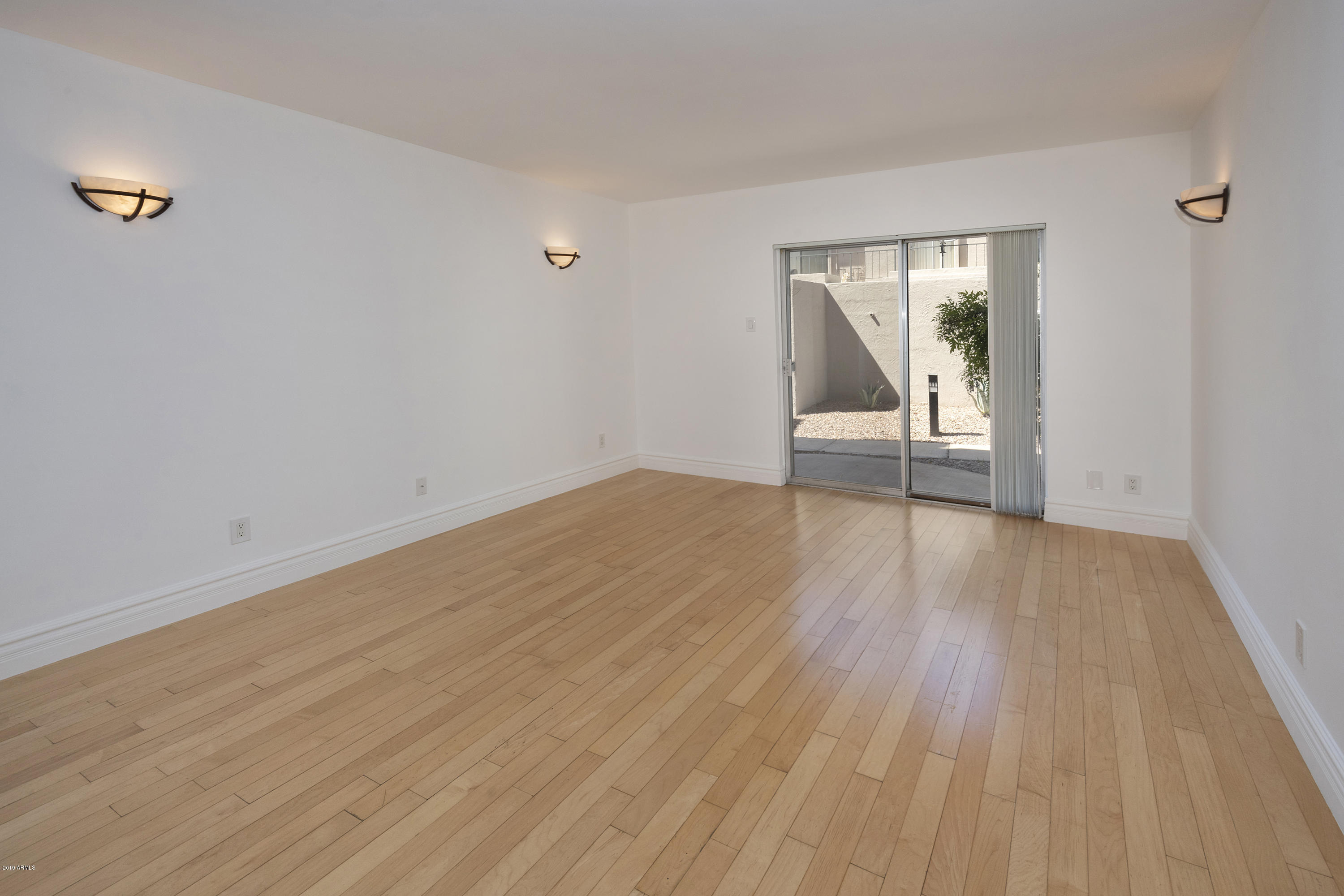 1010 East Osborn Road, Unit A Phoenix, AZ 85014 - Photo 3 of 19 a view of an empty room with wooden floor and a window
