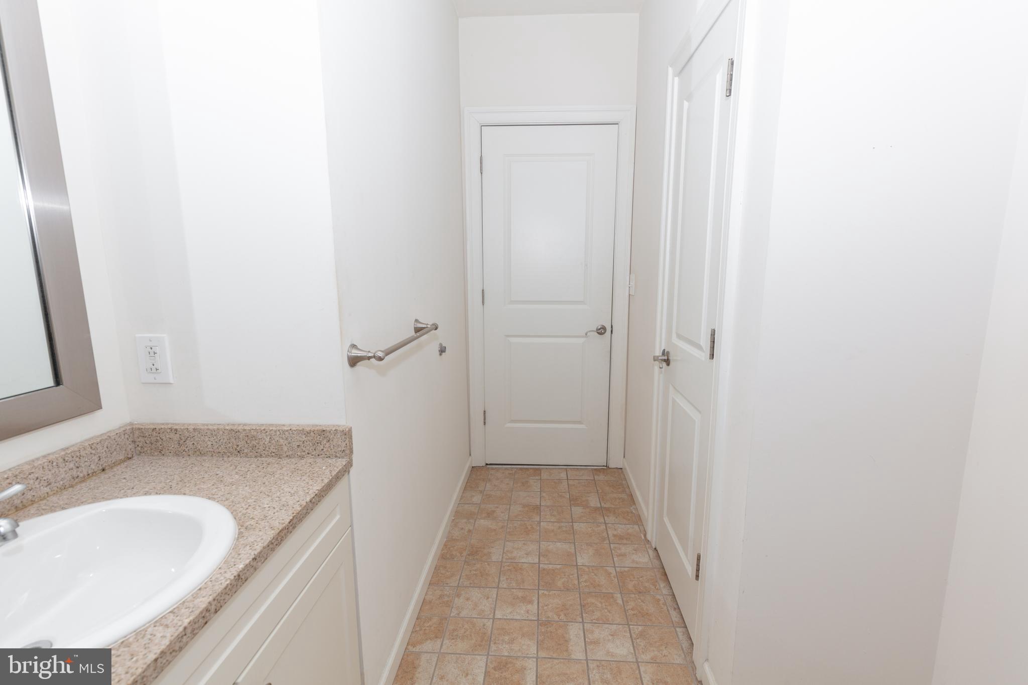 1411-2 Walnut Street, Unit 312 Philadelphia, PA 19102 - Photo 17 of 23 a bathroom with a granite countertop sink a mirror and a vanity