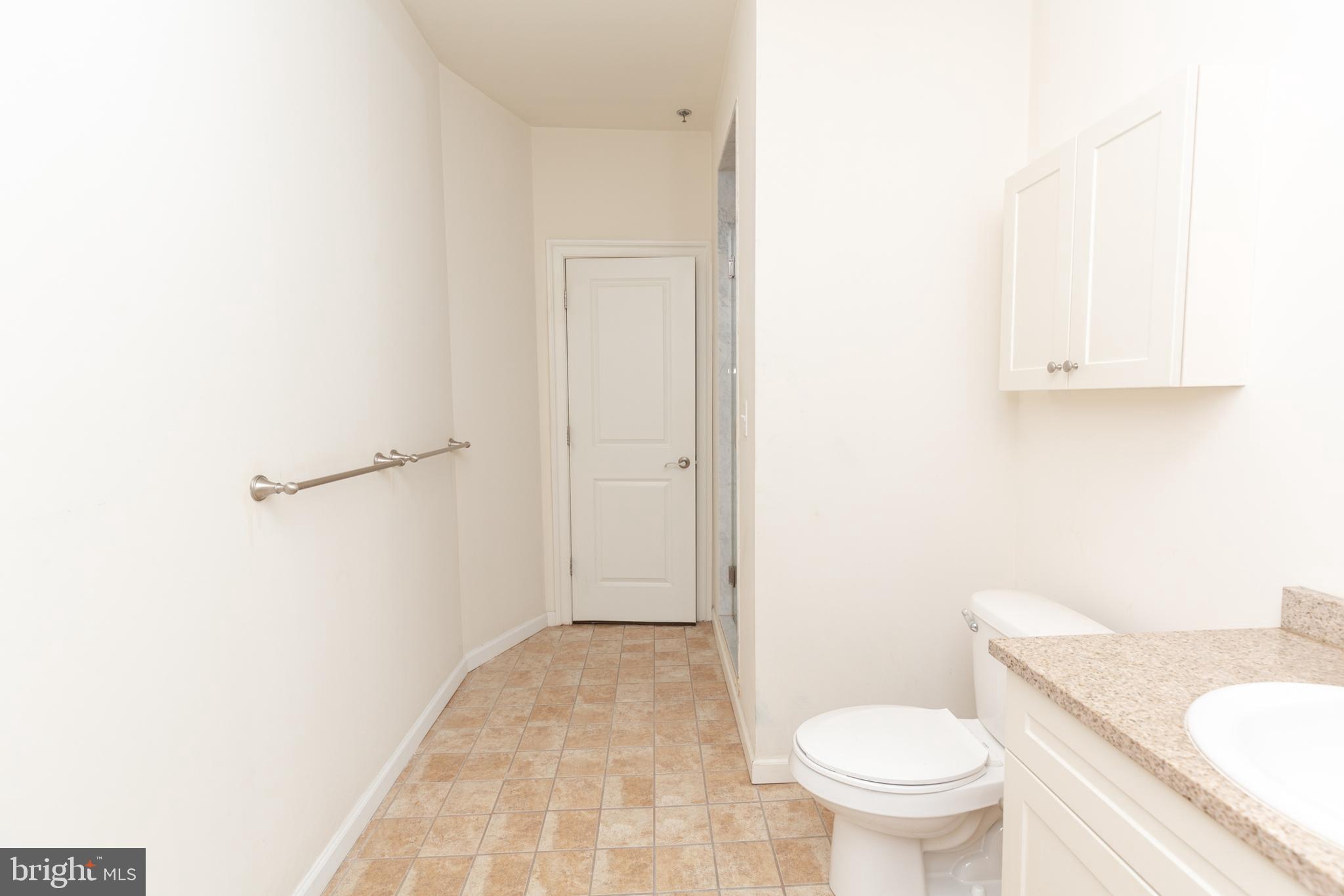 1411-2 Walnut Street, Unit 312 Philadelphia, PA 19102 - Photo 20 of 23 a bathroom with a granite countertop toilet and a sink