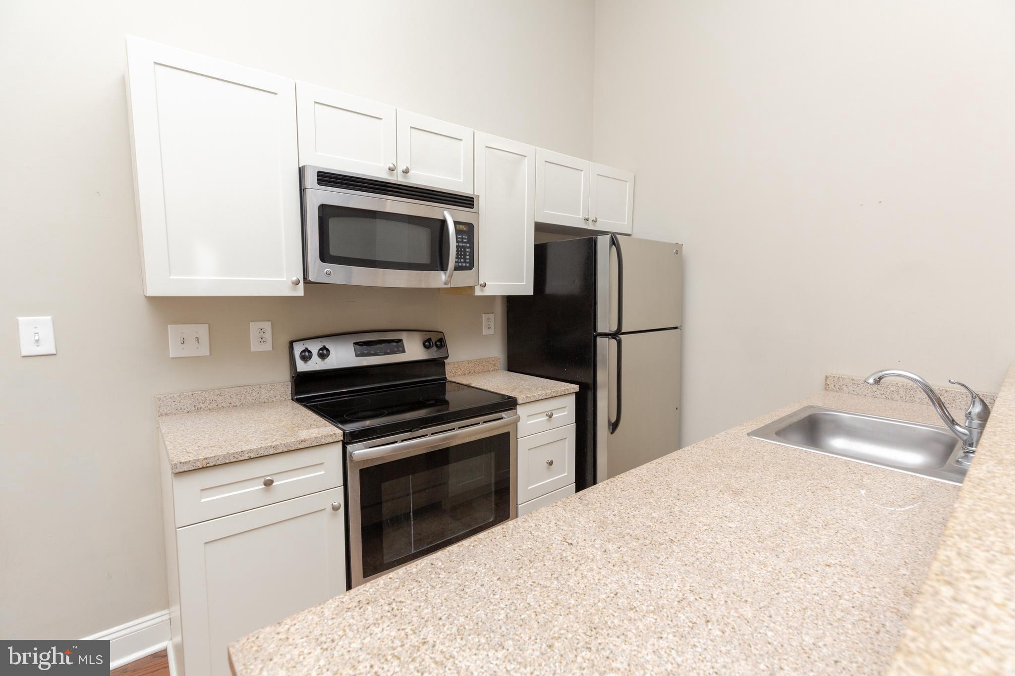 1411-2 Walnut Street, Unit 312 Philadelphia, PA 19102 - Photo 7 of 23 a kitchen with a sink stove and refrigerator