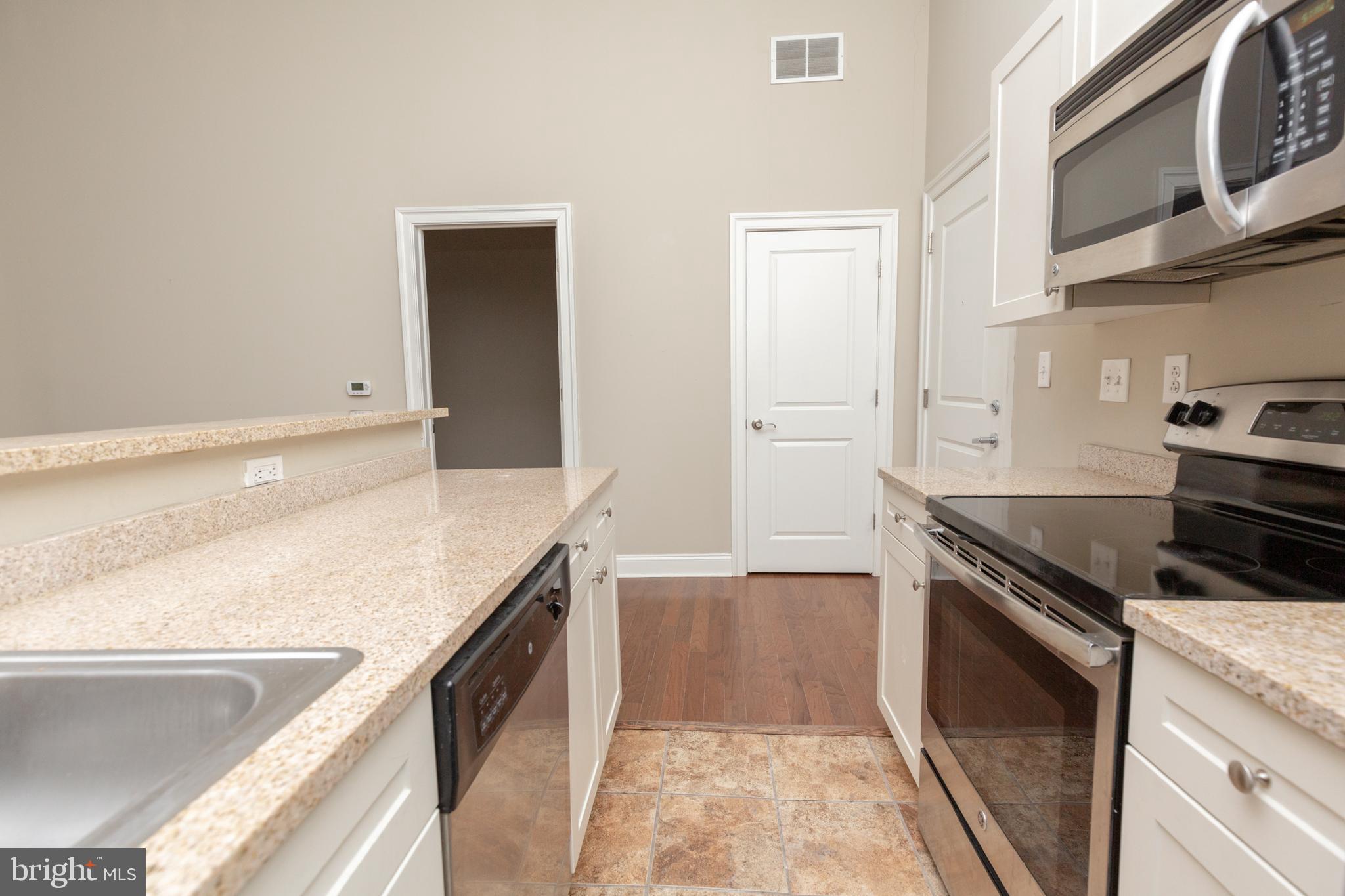 1411-2 Walnut Street, Unit 312 Philadelphia, PA 19102 - Photo 9 of 23 a kitchen with granite countertop a sink and stove top oven