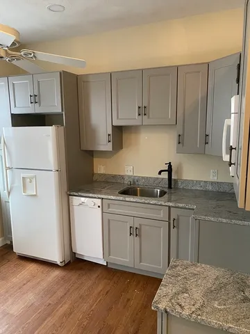 a kitchen with white cabinets sink and refrigerator