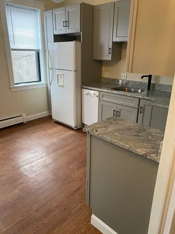 a kitchen with a sink a stove a refrigerator and cabinets