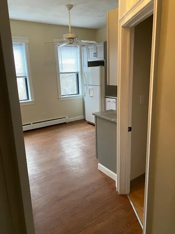 a view of an empty room with window and wooden floor