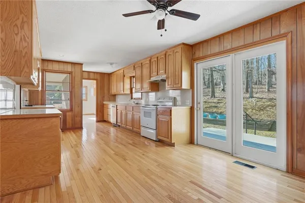 a kitchen with stainless steel appliances granite countertop wooden cabinets a refrigerator a sink and a stove