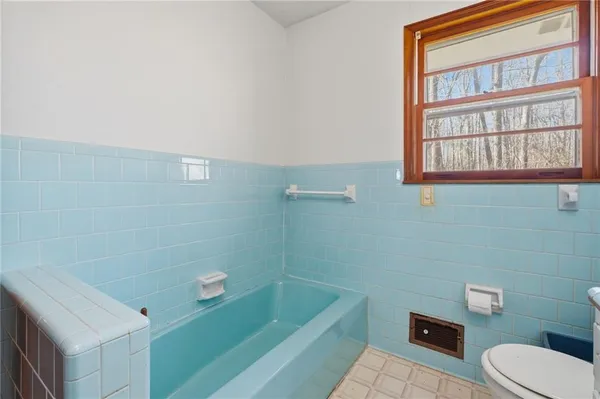 an empty room with wooden floor chandelier fan and windows