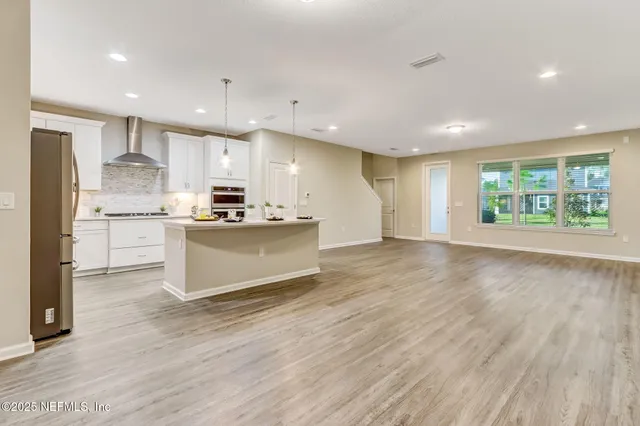 a kitchen with a sink and wooden floor
