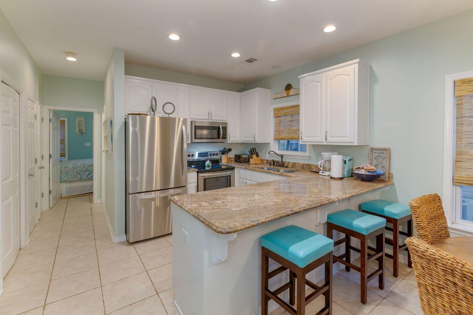 474 Hidden Lake Way Santa Rosa Beach, FL 32459 - Photo 6 of 34 a kitchen with stainless steel appliances granite countertop a refrigerator a sink a stove a dining table and chairs