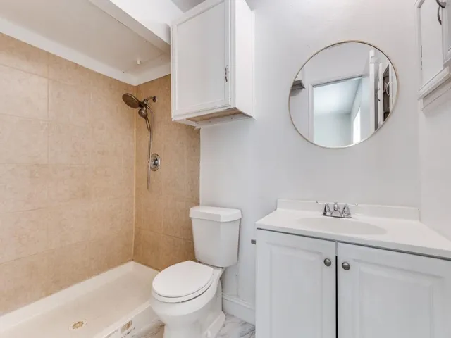 a bathroom with a toilet a sink and mirror