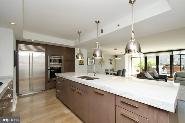 a large kitchen with kitchen island a large counter space a sink appliances and a counter top space