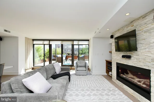 a living room with furniture a flat screen tv and a fireplace