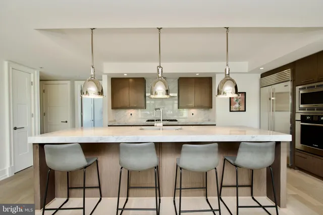 a kitchen with a center island and chairs in it