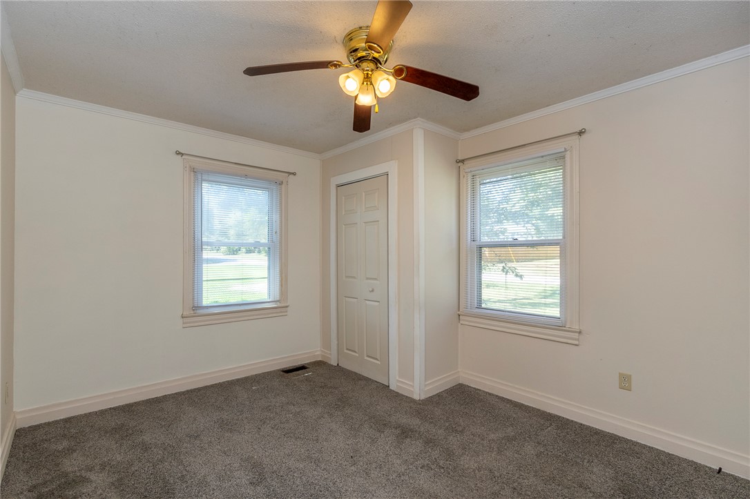 201 Blue Ridge Circle Belton, SC 29627 - Photo 9 of 30 Double windows frame views of the yard in this classic carpeted bedroom with crown molding.