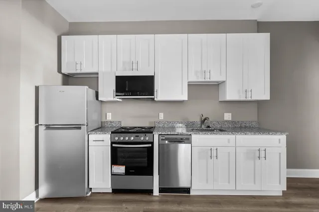 a kitchen with white cabinets and stainless steel appliances