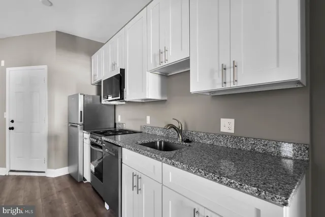 a kitchen with stainless steel appliances granite countertop a sink a stove and a refrigerator