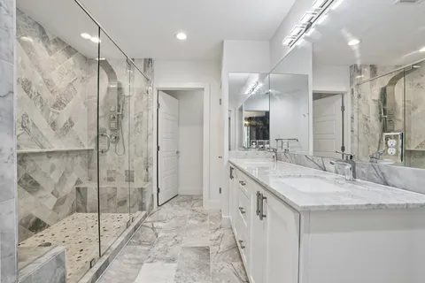 a bathroom with a granite countertop sink mirror and shower