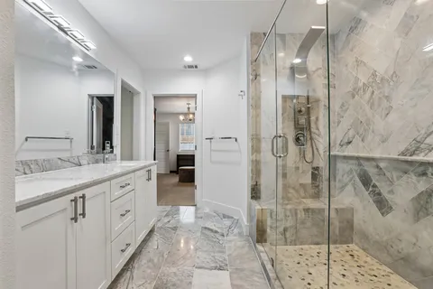 a bathroom with a granite countertop sink mirror and shower