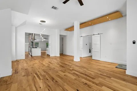 a view of empty room with wooden floor and windows
