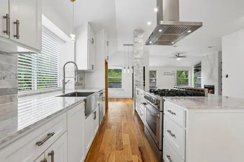 a large kitchen with stainless steel appliances granite countertop a stove and a sink