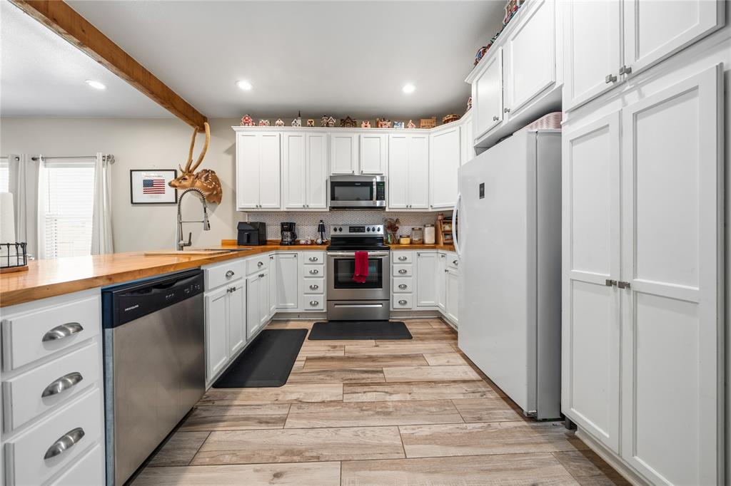 105 South 6th Street Celeste, TX 75423 - Photo 5 of 34 a large white kitchen with stainless steel appliances granite countertop a stove a sink and a refrigerator