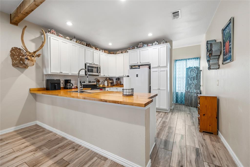 105 South 6th Street Celeste, TX 75423 - Photo 6 of 34 a view of kitchen with stainless steel appliances granite countertop a refrigerator a sink dishwasher and a stove with wooden floor