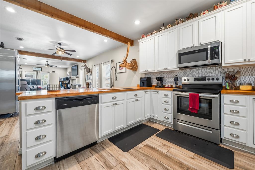 105 South 6th Street Celeste, TX 75423 - Photo 7 of 34 a kitchen with stainless steel appliances a stove microwave and cabinets