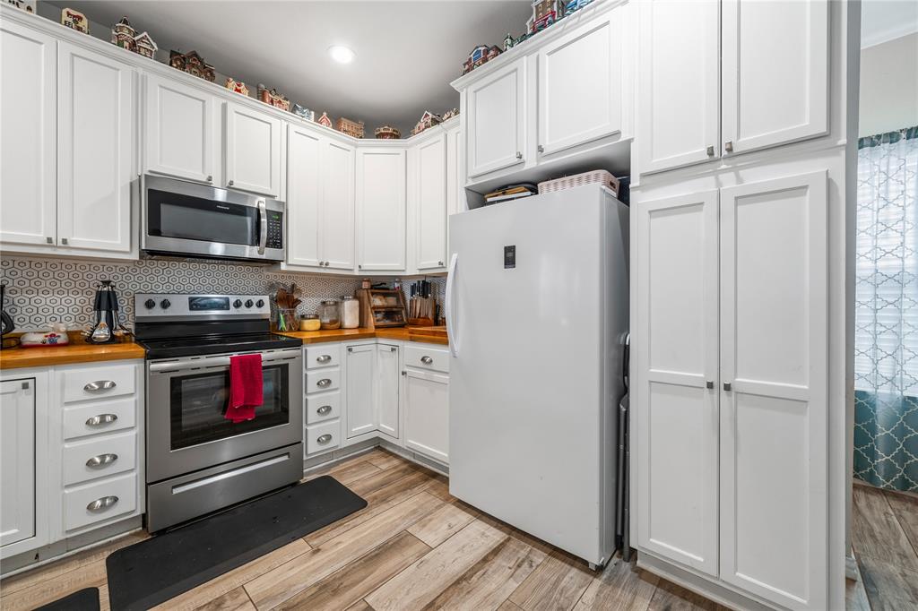 105 South 6th Street Celeste, TX 75423 - Photo 9 of 34 a kitchen with stainless steel appliances granite countertop a refrigerator stove and white cabinets