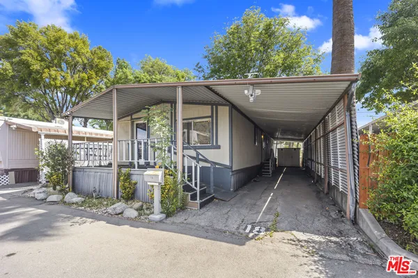 a view of a house with a patio and a yard
