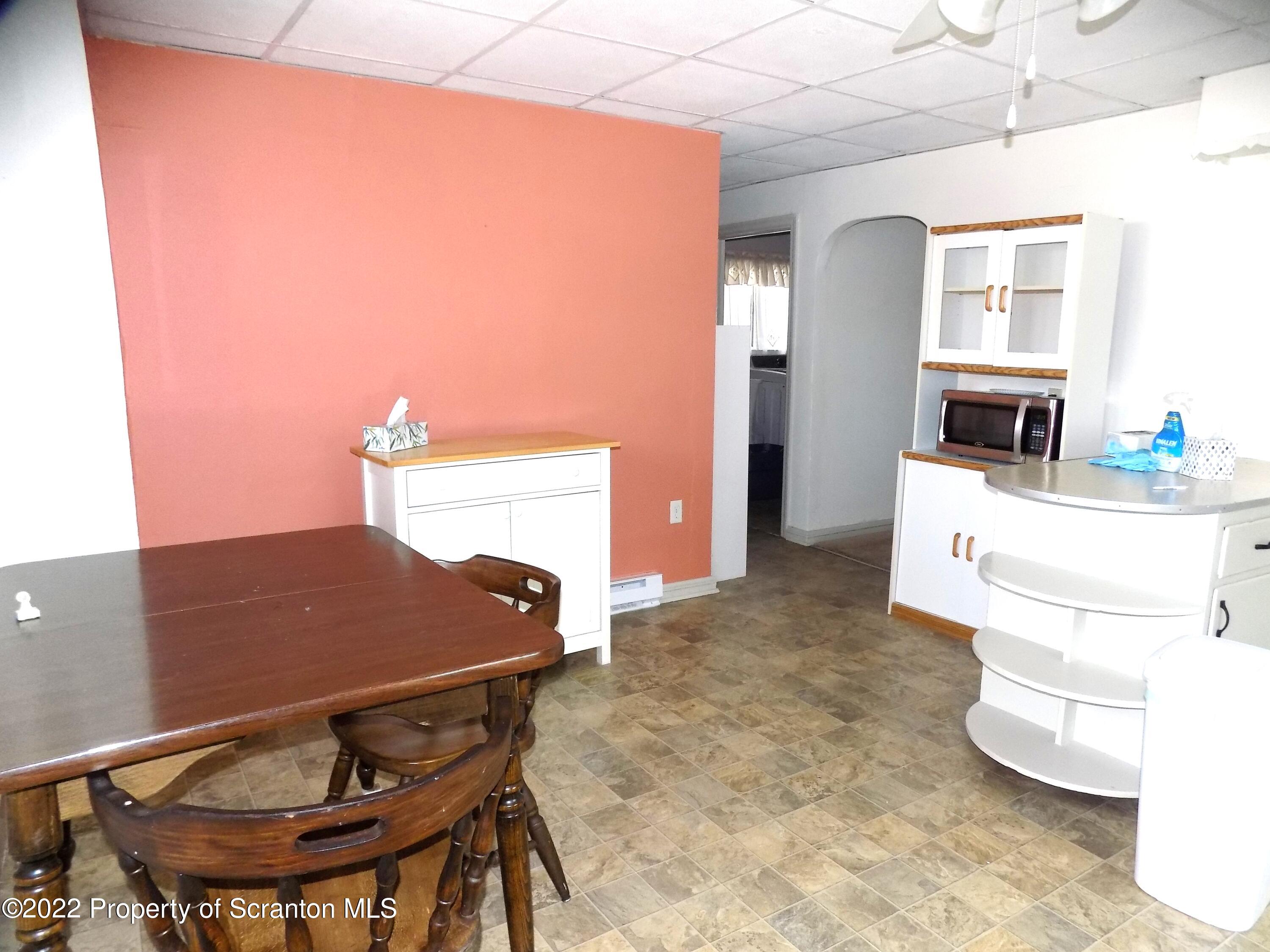 624 Court Street Scranton, PA 18508 - Photo 4 of 13 a living room with a table chairs and a refrigerator