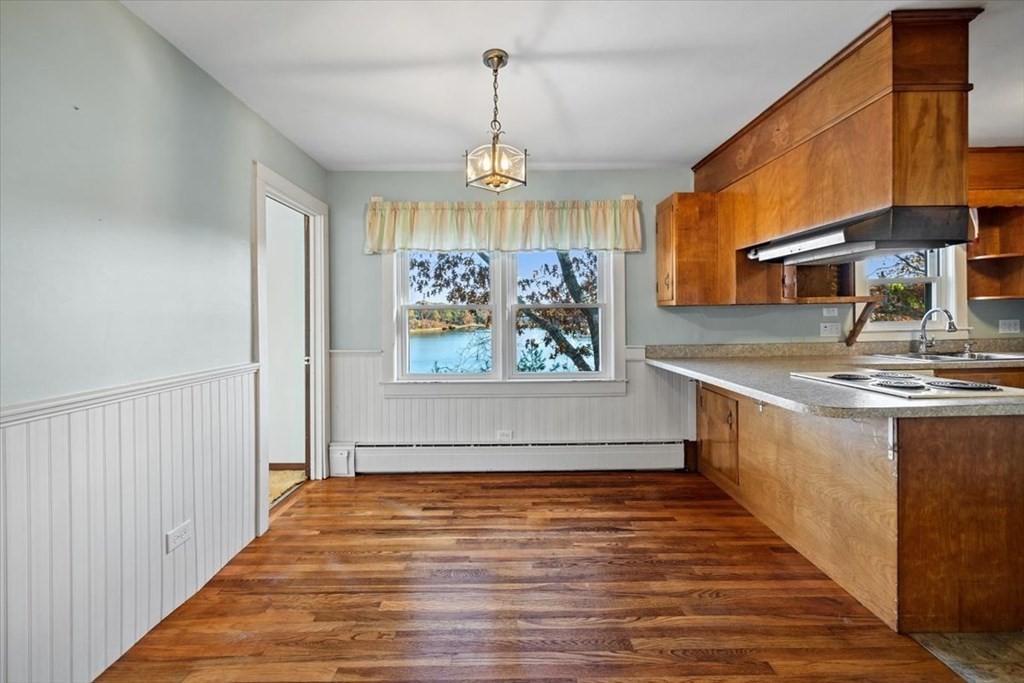 12 Nye Lane Bourne, MA 02532 - Photo 21 of 38 a view of kitchen with granite countertop cabinets a sink and a chandelier